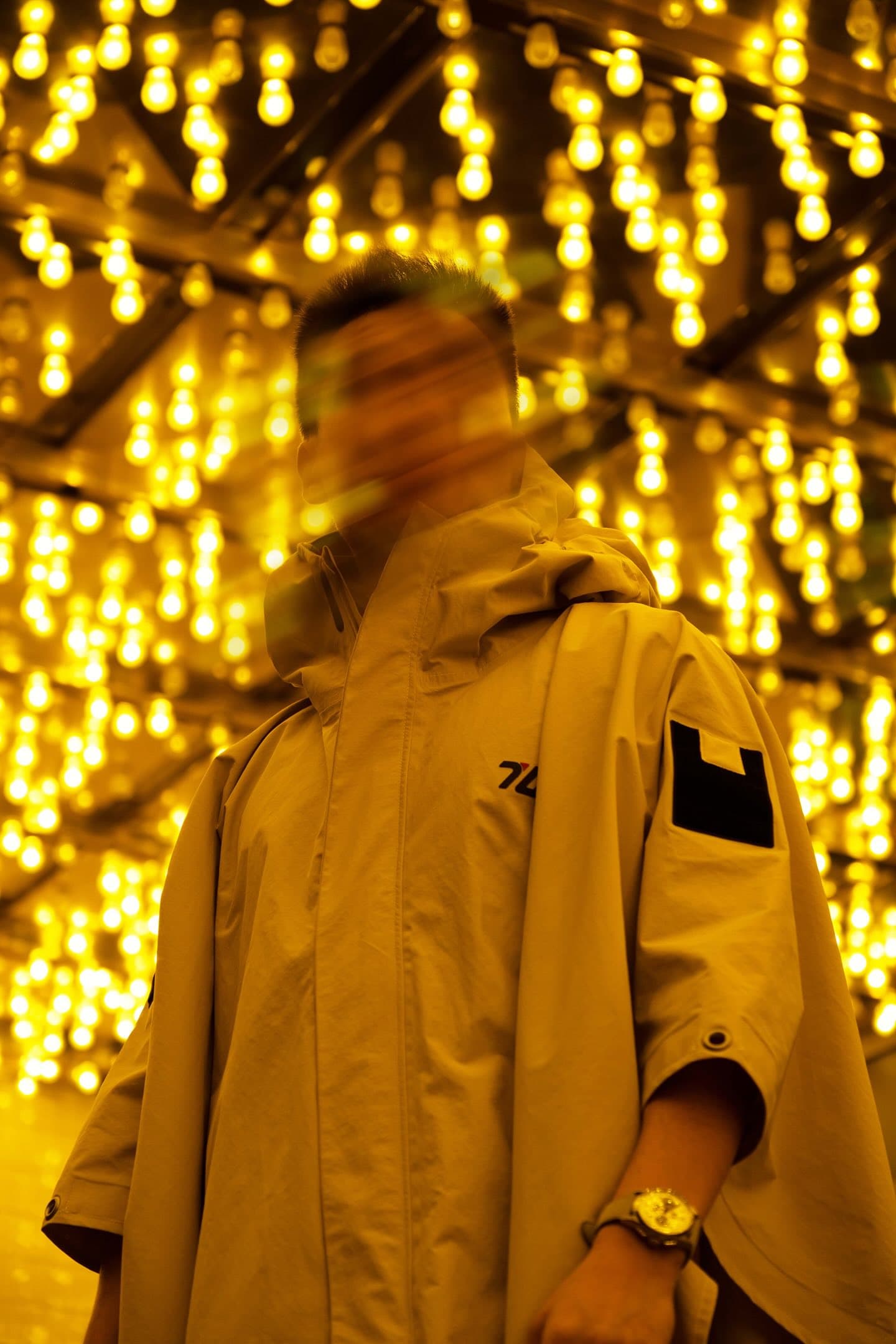 Person in terrain unknown tactical rain poncho with 80's retro lighting blurred background